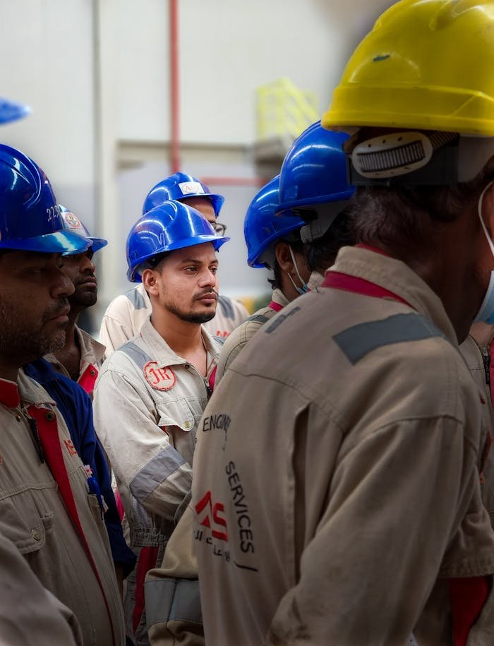 Group of male workers wearing safety helmets on a construction site in Doha, Qatar.